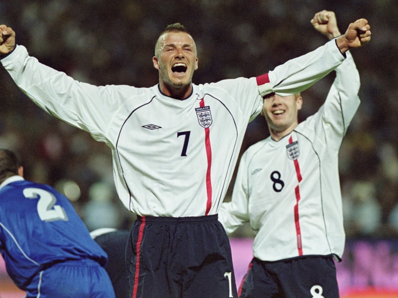 Beckham, sporting his famous mohawk haircut, celebrates after scoring a trademark free-kick against Greece during qualifying for the 2002 World Cup