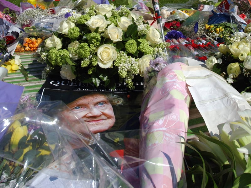 A picture of the Queen Mother lays beside flowers mourners placed on their way to Westminster Hall, where coffin lay in state in April 2002. The queue to enter Westminster Hall was 2km long and lasted for seven hours