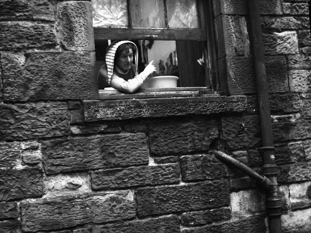 A resident of Prospect Place shouts at the Edinburgh Town Councillors touring the city slums in the St Leonard's area in December 1959. The slums were demolished in the early 1960s.
