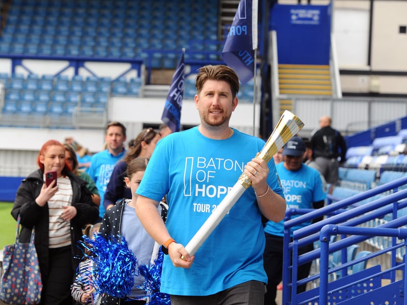Portsmouth FC fan Daniel O'Brien carries the baton through Fratton Park.