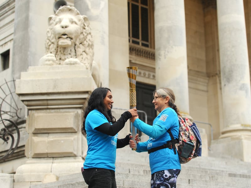 Maya Choudhury (16) takes the baton from Annette Covey at Portsmouth Guildhall.