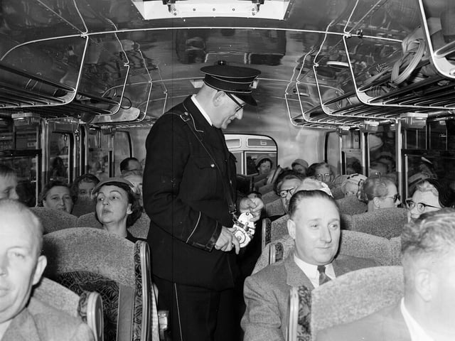 A conductor takes fares on a 1958 city bus.