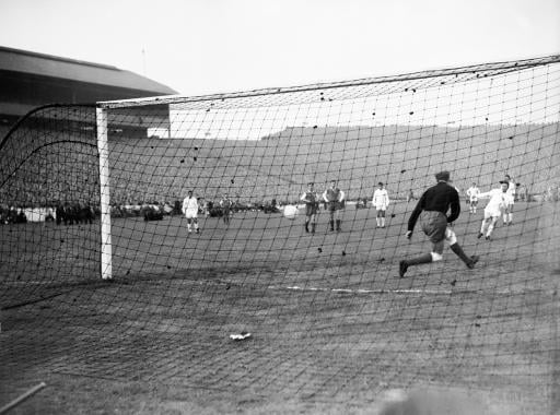 Real Madrid's Ferenc Puskas (r) sends Eintracht Frankfurt goalkeeper Egon Loy (second r) the wrong way from the penalty spot to score his team's fourth goal