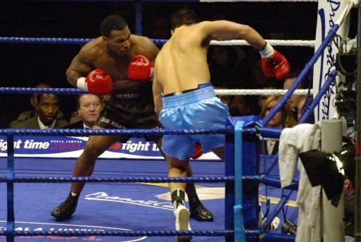 Former World Champion Mike Tyson (left) knocks down Lou Savarese during their heavyweight contest at Hampden Park in Glasgow.