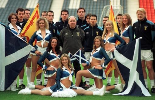Scotland manager Craig Brown poses with the cheerleaders of the Scottish Claymores American football team. They performed at the Scotland vs England Euro 2000 playoff at Hampden a few days later.