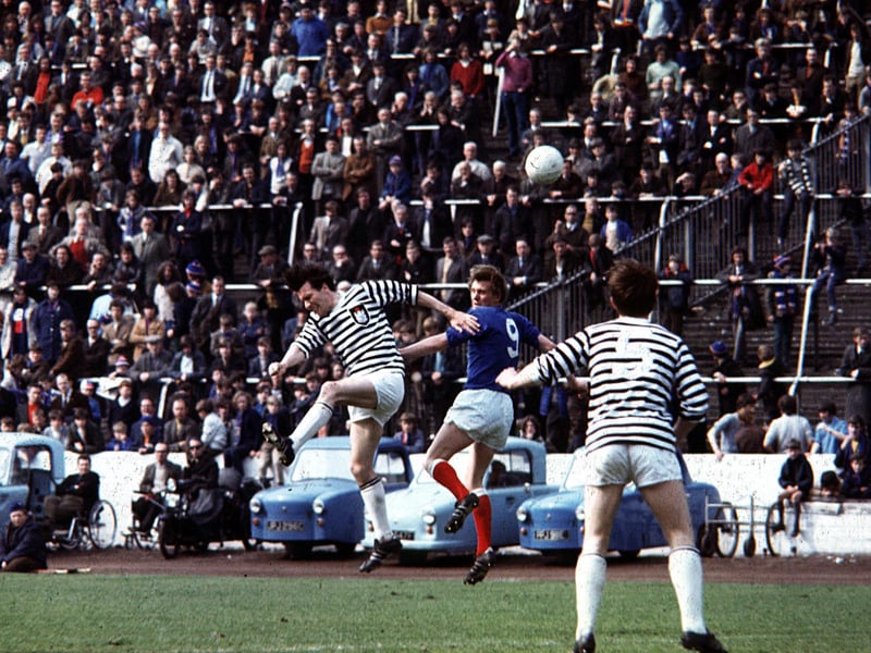 Colin Stein attempts to out jump two Queen's Park defenders as Rangers take them on at Hampden.