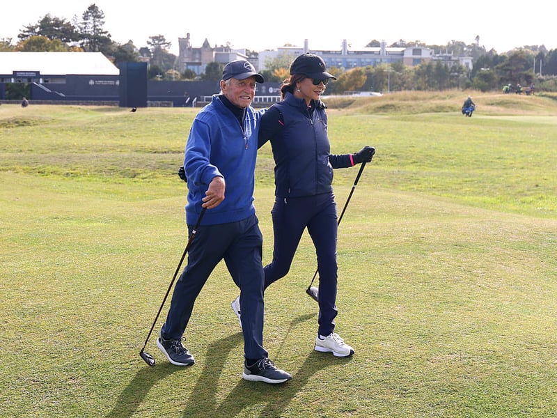 Michael Douglas and Catherine Zeta-Jones play a practice round at the Old Course prior to the championship.