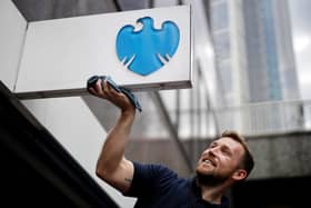 A man cleans a sign outside a branch of a Barclays bank in the City of London. The banks is offering up to £900 in cash to new customers who switch their current account and ISA (Photo: TOLGA AKMEN/AFP via Getty Images)