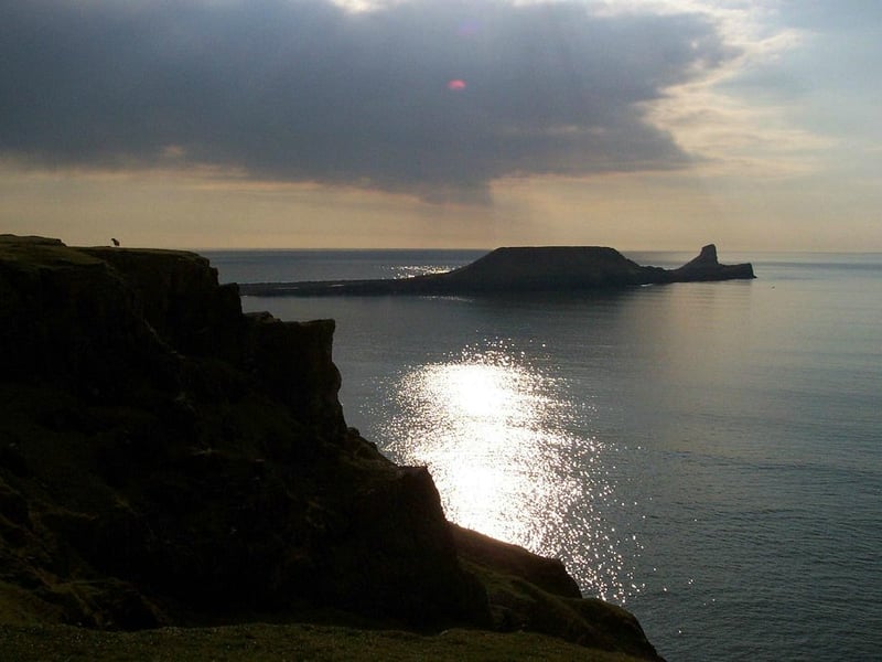 Voted one of the UK’s best beaches, Rhossili Bay is a spectacular, three-mile-long expanse of sand, tying with a score of 6.60/10. This dramatic, windswept beach offers truly magnificent views of the Gower Peninsula and Worm's Head, a natural causeway that leads to a rocky island. It's a spectacular spot for a challenging walk and is particularly popular with surfers and paragliders.