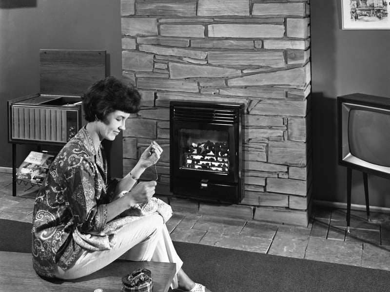 A woman is seen knitting in front of a fire in this 1966 advert for British Coal