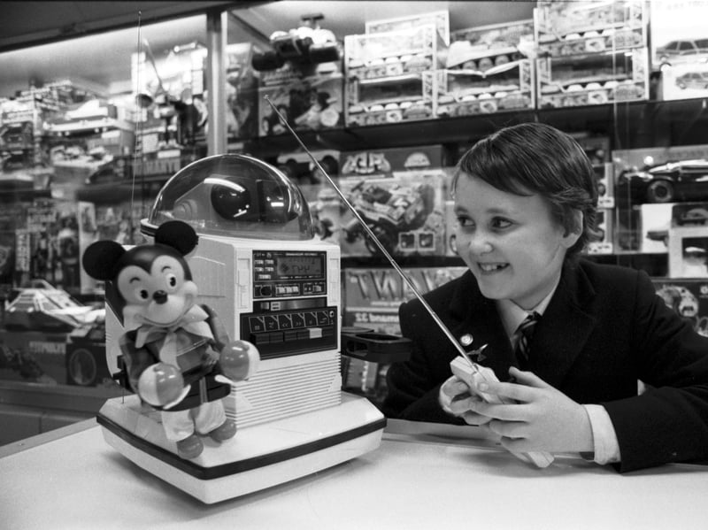 Elliot Blythe plays with a remote-controlled Omnibot robot at Jenners department store in Edinburgh, in November 1986