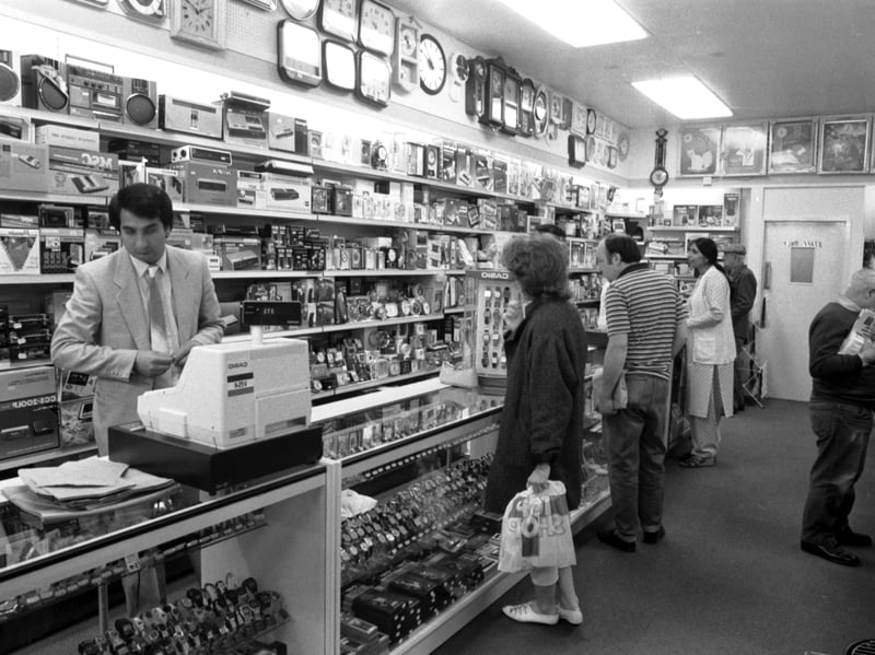 Mr Azra behind the counter of Ali's Cave discount store on Edinburgh's South Bridge in June 1985