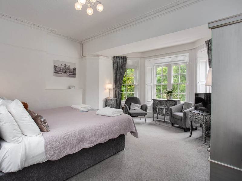 One of the more modern rooms in the hotel, featuring high ceilings, large windows and leafy views 