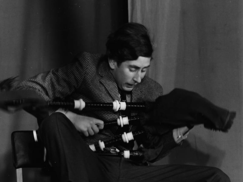 Prince Charles jokes around with a set of bagpipes as he appears on stage in a student revue at Trinity College, Cambridge University, in February 1970