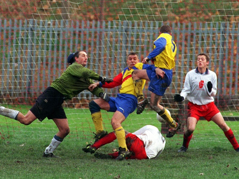Dewsbury Road goalkeeper Warren Wood is too late to keep out Holbeck's Richard Helliwell during the Leeds Combination League Premier Division clash in November 1999.