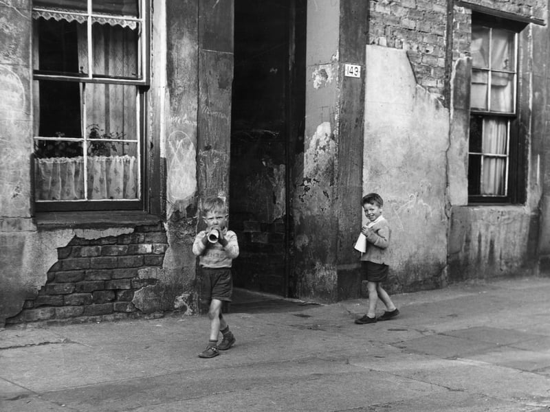 Two young boys playing with makeshift loudspeakers outside in the Gorbals district of Glasgow, which was described as having the worst slums in Europe, in 1961