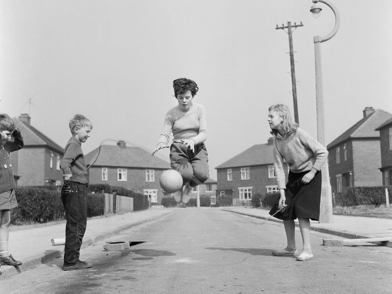Twelve-year-old footballer Margaret Wilde bounces and catches a football while skipping, as part of her training regime, in a street near her home in Denton, near Manchester, in April 1960. Holding one end of the skipping rope is her friend Brenda Brook (12). Wilde was the youngest member of Nomad Ladies Football Club, second eleven of the Manchester Corinthians L.F.C., who were preparing for an international tour.