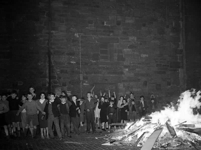 Children watch a bonfire in the Holyrood area of Edinburgh on Guy Fawkes Night 1956.