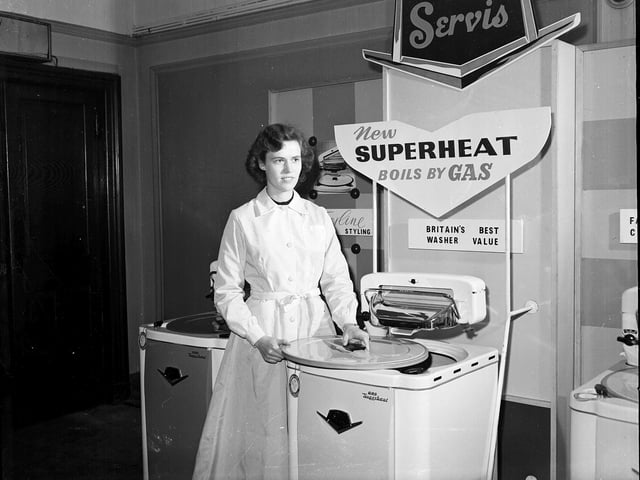 Miss Copeland demonstrates a gas powered Servis washing machine with an attached wringer as part of an 'Evening Dispatch Housewives Demonstration'.