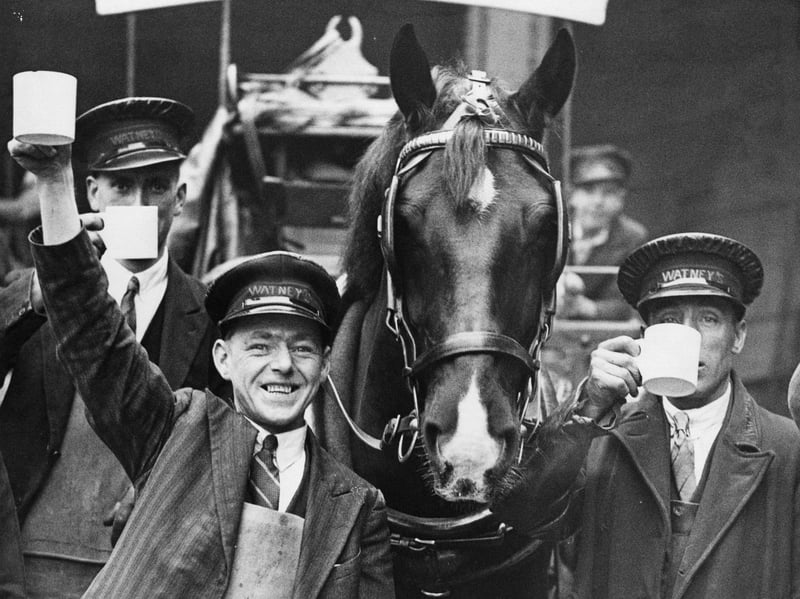 Draymen from Watney's brewery drink to the health of their drayhorse after it won the 'Cambridgeshire' competition in 1934