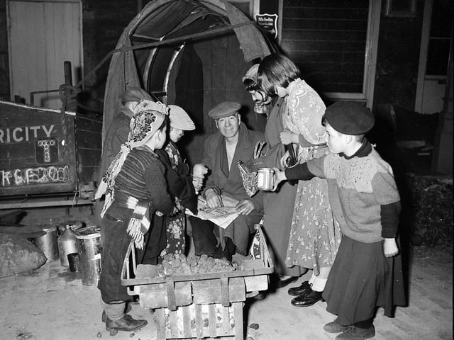 Halloween guisers visit a night watchman in Edinburgh's Grassmarket in 1957.