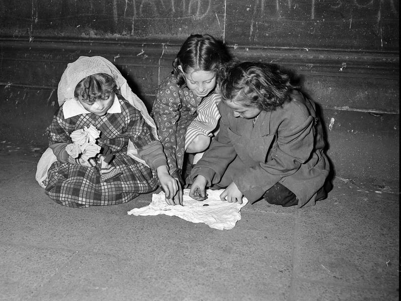 Halloween guisers count their takings in Leith in 1957.