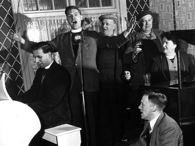 A Methodist reverend singing in a Yorkshire pub during a Rock and Roll Religion tour of local mining hostelries, operated out of a caravan by two 26-year-old parsons, in 1957