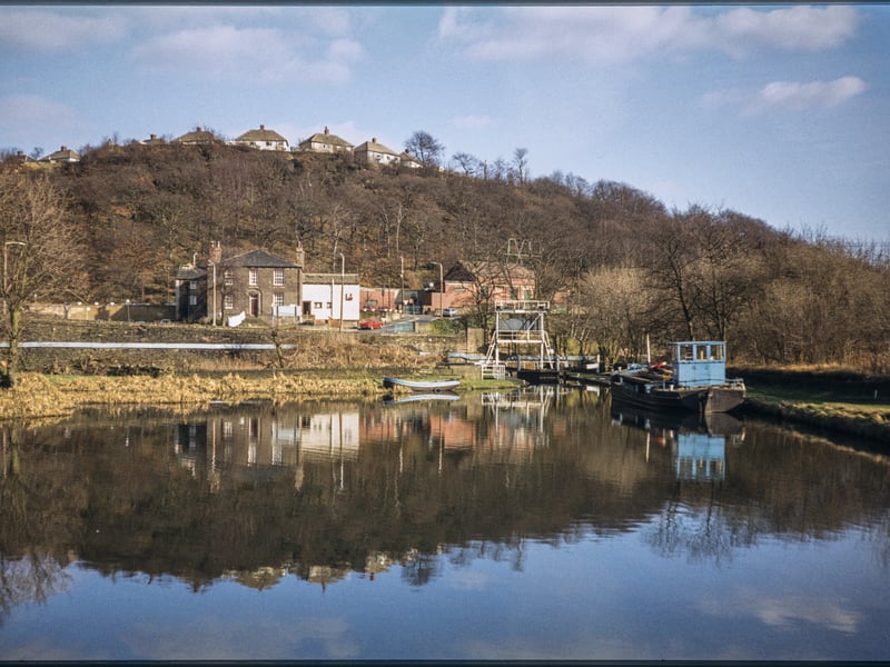 The view looking east across Salterhebble Low Basin on the Calder and Hebble Navigation, Halifax, in 1980, with the Calder and Hebble Inn (now demolished) beyond the basin, and homes on Chevinedge Crescent in the background