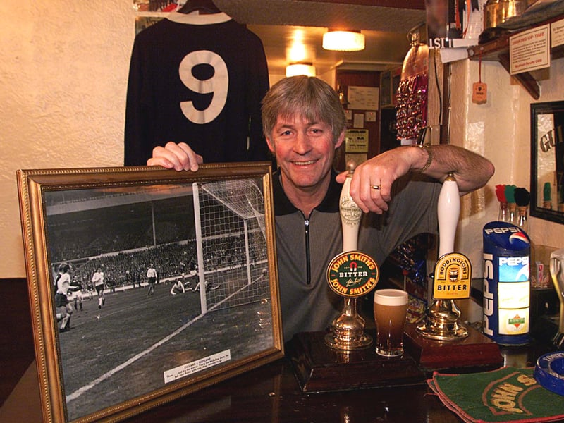 Ex-Scotland International Jim McCalliog pictured with the shirt he wore in 1966 and a photo of his goal when Scotland beat England. Jim was decorating his pub, The George and Dragon, in Wetherby, in November 1999, ready for the oldest International clash the following day.
