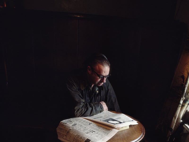A solitary pubgoer catches up on some reading in the Crown Inn pub in the rural village of Hawes, Wensleydale, Yorkshire, in around 1982