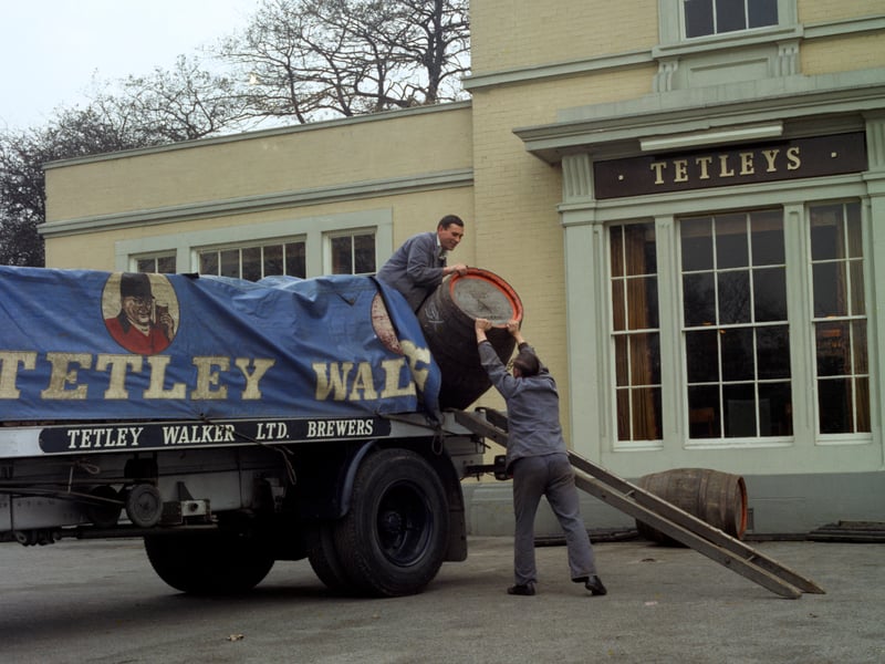 Draymen from Tetley & Walker, Leeds, unloading beer barrels during a delivery to a pub in 1969