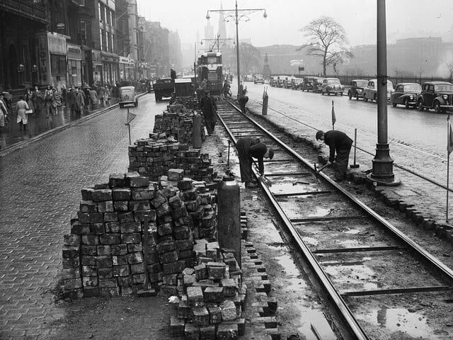 Workers carry out major road repairs along the edge of the tram lines on Edinburgh's Prince Street in 1953.
