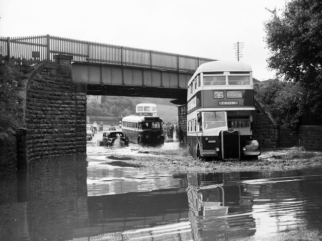 A bus ploughs through the water under Slateford Railway Bridge. Torrential rain during a thunderstorm took just 15 minutes to cause flood damage in Edinburgh in July 1953.