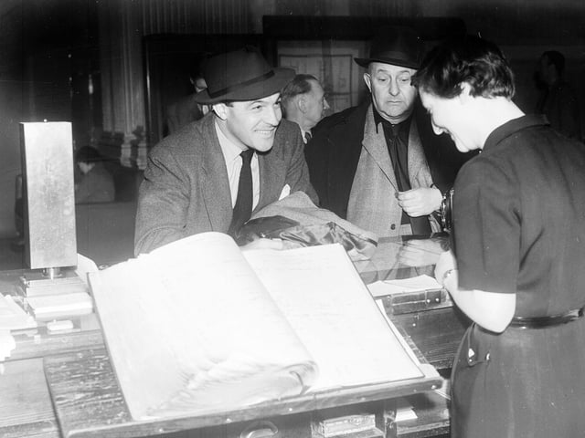 Actor Gene Kelly with film producer Arthur Freed checking in at the Caledonian Hotel, Edinburgh, in April 1953.