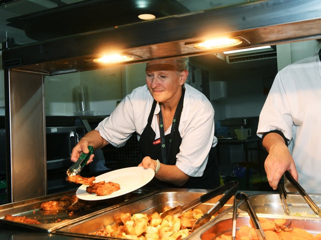Tina Horton serves up food donated by Chick-fil-A at St George's Crypt.