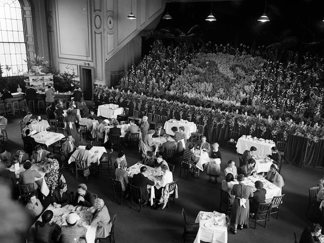 Lunch time at the Festival Club during the 1953 Edinburgh Festival. A lion rampant in flowers forms part of the decorations.