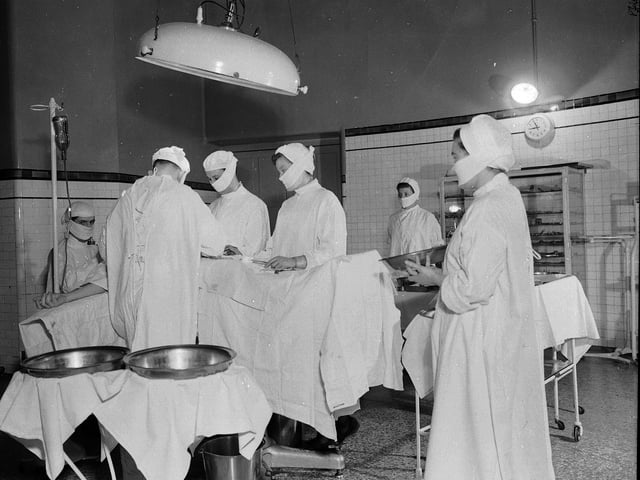 Surgeons and nurses in the Leith Hospital operating room in April 1953