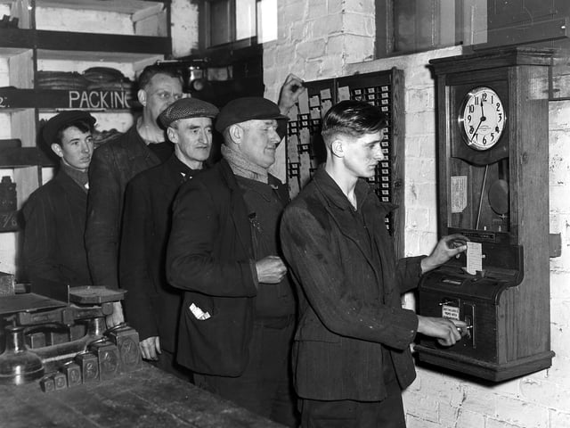Men clocking-in at the time clock in the shale oil works at Roman Camp, in Broxburn, in 1950.