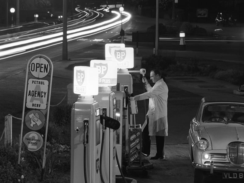An attendant fills up a car at a petrol station in Cheltenham, Gloucestershire, in May 1963