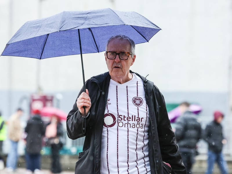 Hearts fans arrive at a rainy Tynecastle ready for the game against Celtic.