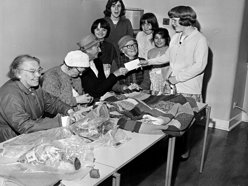 Carol Walker hands over a donations cheque to Mrs J Ree for Lamb's House Old Folks Club in Leith in 1964.