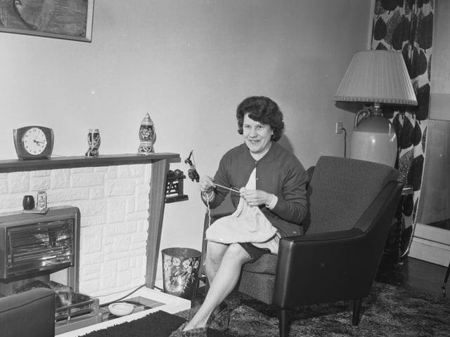 Mrs Mary Eves sits knitting in the sitting room of her new home at Cables Wynd, in Leith, in April 1966.