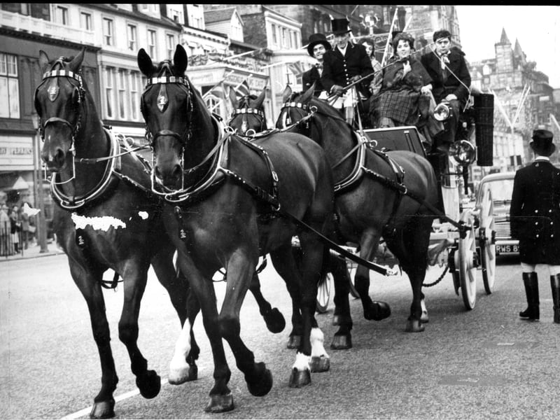 Members of the cast of 'The Doctor and the Devils' at the Assembly Hall travel along Princes Street in a handsome Gilby coach-and-four horse drawn carriage during the Edinburgh Festival in August 1962.