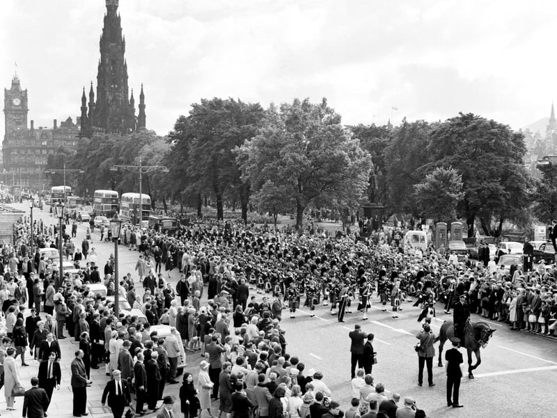 Crowds gather to watch the Edinburgh City Police Pipe Band as it marches along Princes Street during the Edinburgh Festival in August 1966.