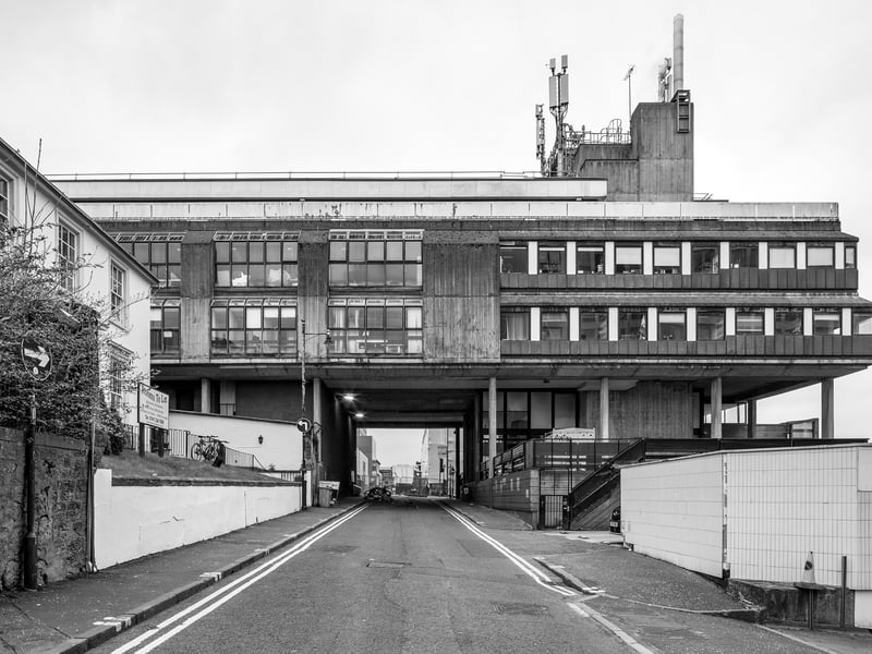 The Bourdon Building at the Glasgow School of Art, completed around 1977, has the appearance of a strange, battered almost distressed Brutalist spacecraft, looming over Scott Street on slender pilotis. Its two ribbed concrete storeys, deeply textured with board-marked surfaces, were designed to house the studios and workshops of the School of Architecture. The building stands opposite Mackintosh’s celebrated Glasgow School of Art – a striking juxtaposition, given that Mackintosh designed his masterpiece while employed by Honeyman & Keppie, the predecessor to the Bourdon’s architects, Keppie Henderson & Partners. The result is a dialogue of forms: late era hard-assed brutalism facing off the decorative sensibilities of Mackintosh’s early modernism.