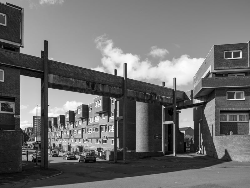 Designed by the Glasgow architectural practice Boswell, Mitchell and Johnston, the Woodside housing development was built between 1970 and 1974 as part of one of the city’s post-war Comprehensive Development Areas. The scheme forms a distinctive group of medium-rise buildings north of the city centre and represents a deliberate move away from the high-rise housing types that dominated the 1960s. Instead, the architects sought to reinterpret the traditional Glasgow tenement in a modern form, creating a village-like arrangement of flats and communal spaces. Boswell, Mitchell and Johnston
had earlier designed major housing at Pollokshaws (1963), but at Woodside alongside the architectural dynamism of the extruded bays, elevated constructivist walkways and bold geometrical incisions, they explored a more congenial and contextually responsive urban model.