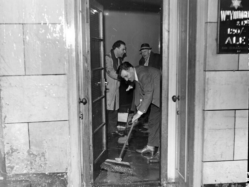  Staff sweep the water out the door of the Halfway House pub in Fleshmarket Close after flooding in Edinburgh in January 1963.