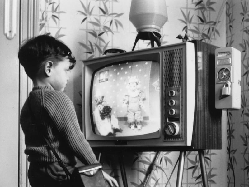 A young boy watches Andy Pandy at home on a pay television in April 1963. A slot meter on the right allows him to insert 6d coins per hour of viewing.