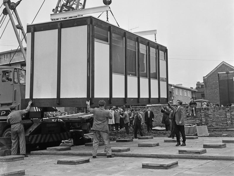 A prefabricated house is lifted into position at its new address in November 1962