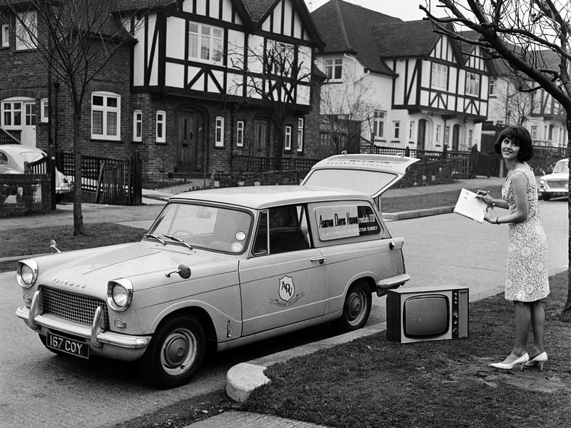 An employee of a TV rental shop delivering a television to a customer in 1961
